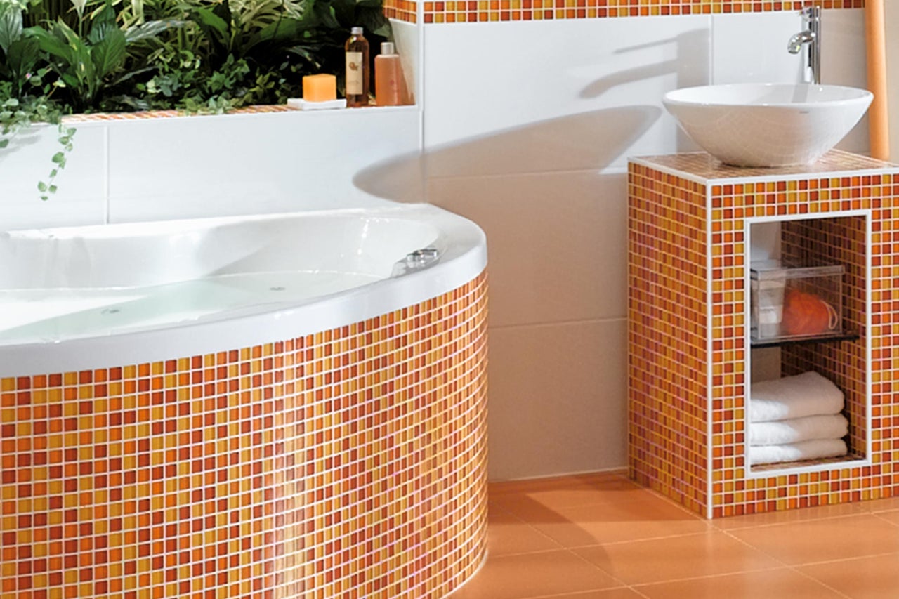 Lichte badkamer met bad, wastafel en mozaïektegels