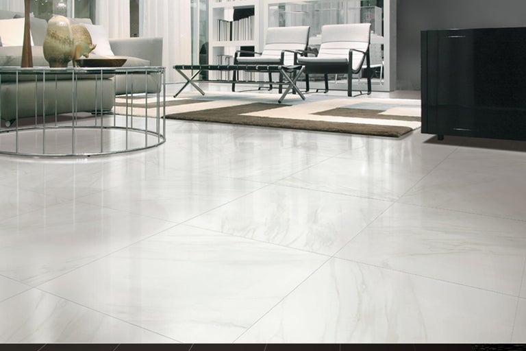 Lichte woonkamer met vloertegels, bank, salontafel en rekken