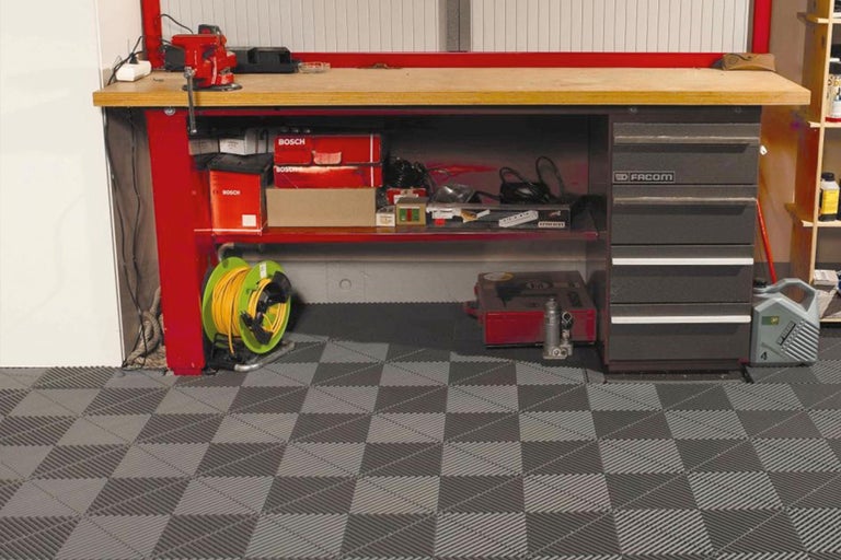 Werkplaats met werkbank, gereedschap en vloertegels