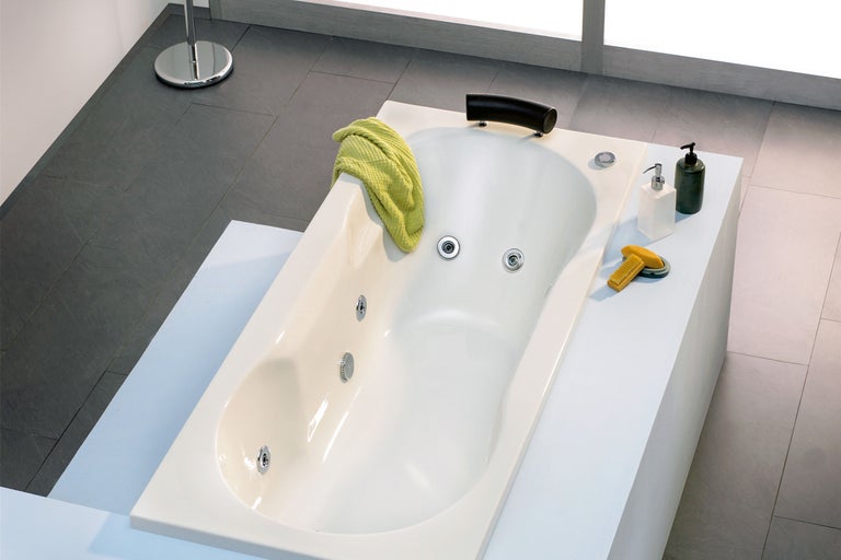 Ingebouwd bad in de badkamer met handdoek, zeep en borstel