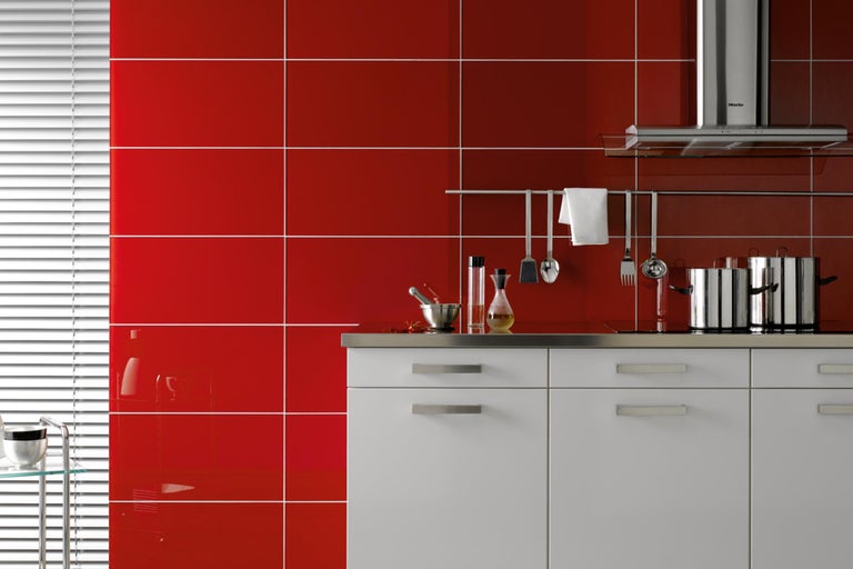 Lichte keuken met rode tegels, witte onderkasten en roestvrijstalen werkblad