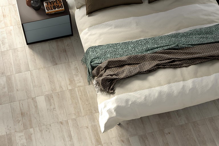 Lichte slaapkamer met houten vloertegels, bed en nachtkastje
