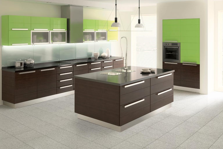 Lichte keuken met kookeiland, spoelbak, ingebouwde oven en groene kastelementen.