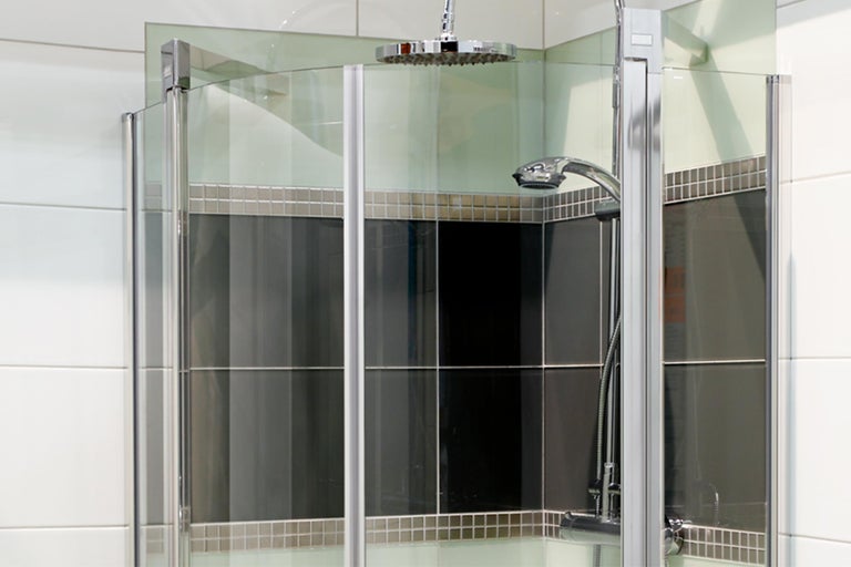 Hoekdouche met douchekop en handdouche in een modern ontworpen badkamer