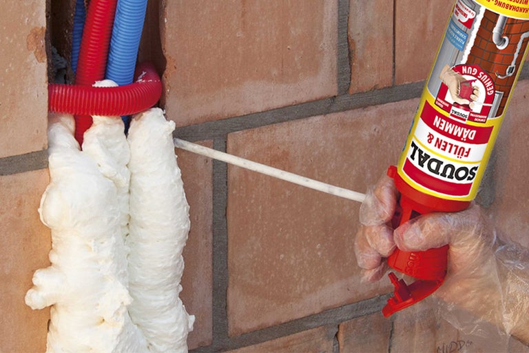 Een muurdoorvoer wordt uitgeschuimd met montageschuim uit een blik van Soudal