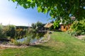 Tuinvijver met beplanting en ligweide onder een parasol Tuinvijver met beplanting en ligweide onder een parasol