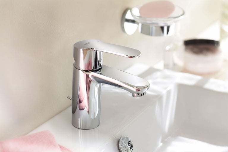 Glanzende kraan op een wastafel met een zeepbakje