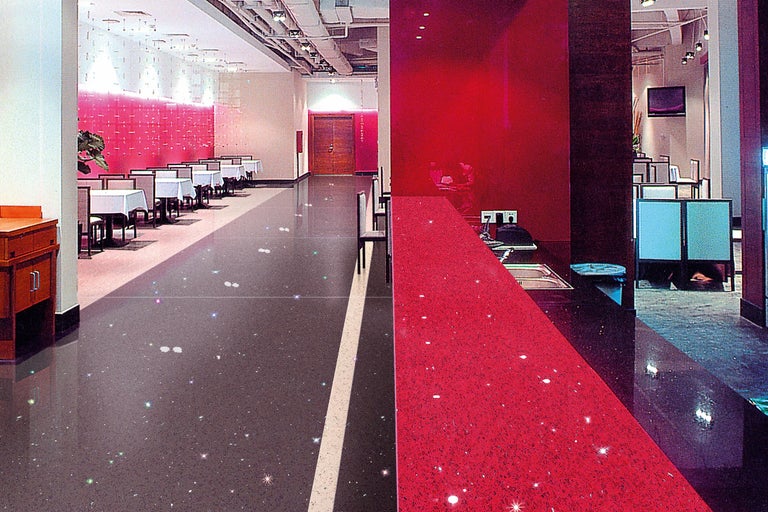 Restaurant met tafels en stoelen en een rode bar met spoelbak