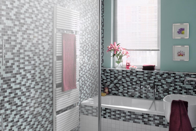 Badkamer met mozaïektegels, bad en handdoekradiator