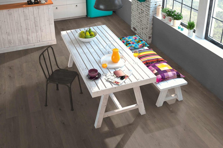 Lichte, vriendelijke eetkamer met houten vloer, eettafel en zitbank met kussens