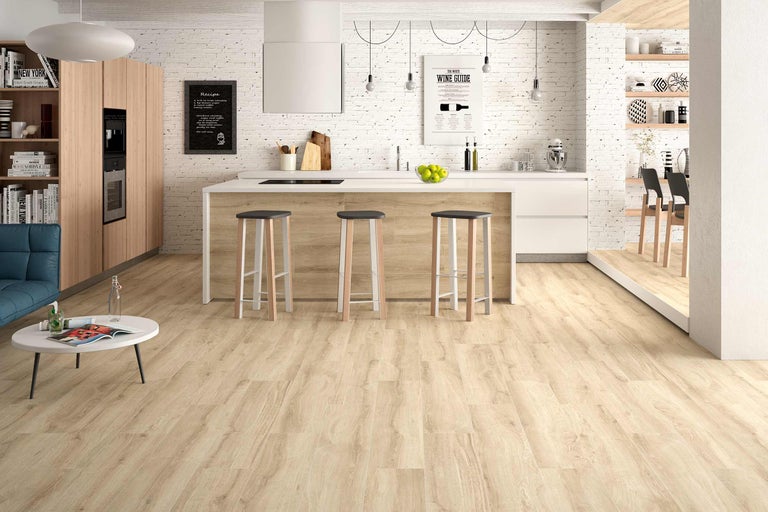 Lichte, moderne keuken met houten vloer, kookeiland, barkrukken en decoratieve elementen voor een uitnodigende sfeer.