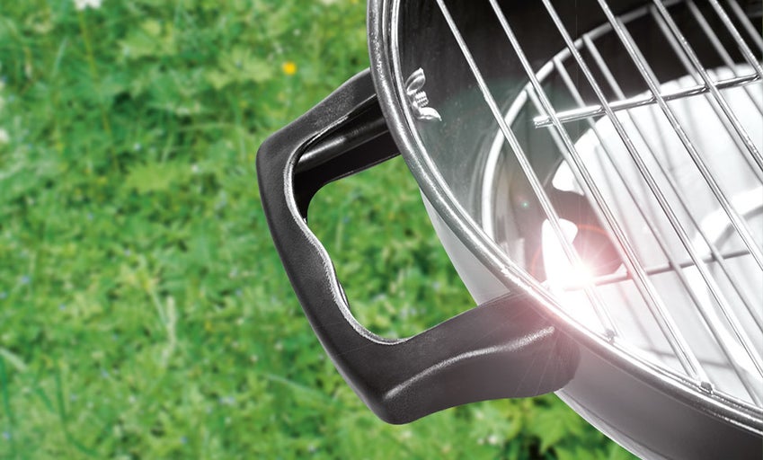 Detailopname van een bolgrill met handvat en grillrooster