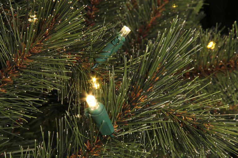 Close-up van een verlichte kunstkerstboom met groene naalden