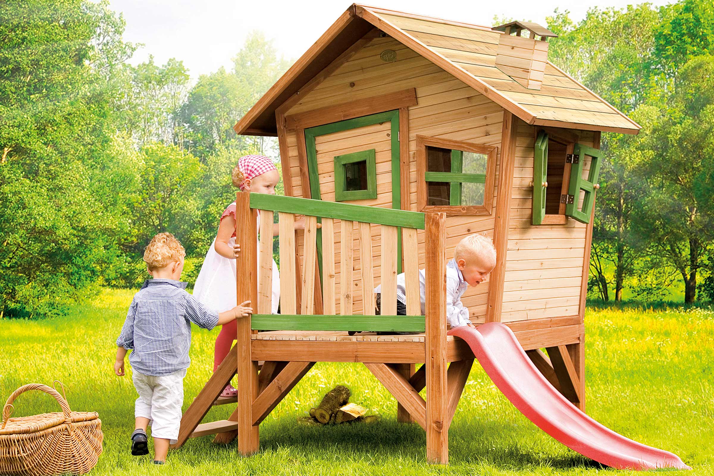 Houten speelhuis met glijbaan in de tuin met spelende kinderen