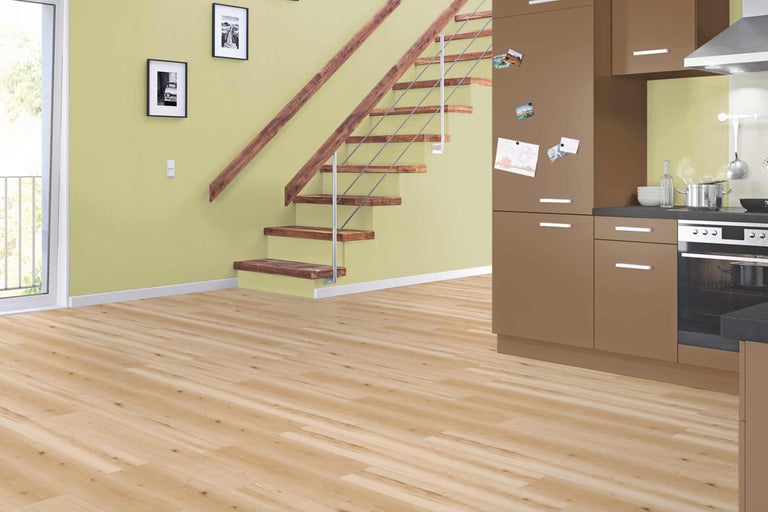 Lichte ruimte met houten vloer, trap en kitchenette