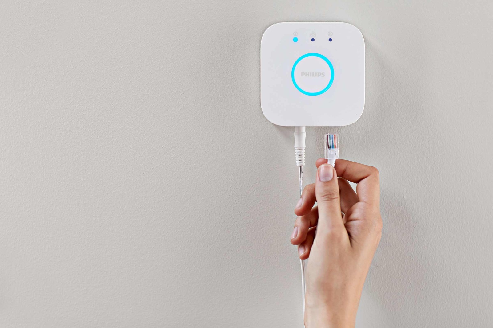 Philips Hue Bridge met netwerkkabel in de hand