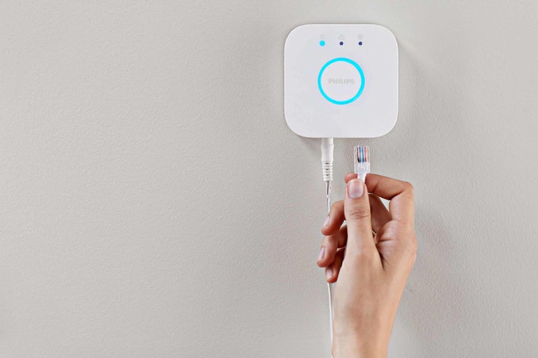 Philips Hue Bridge met netwerkkabel in de hand