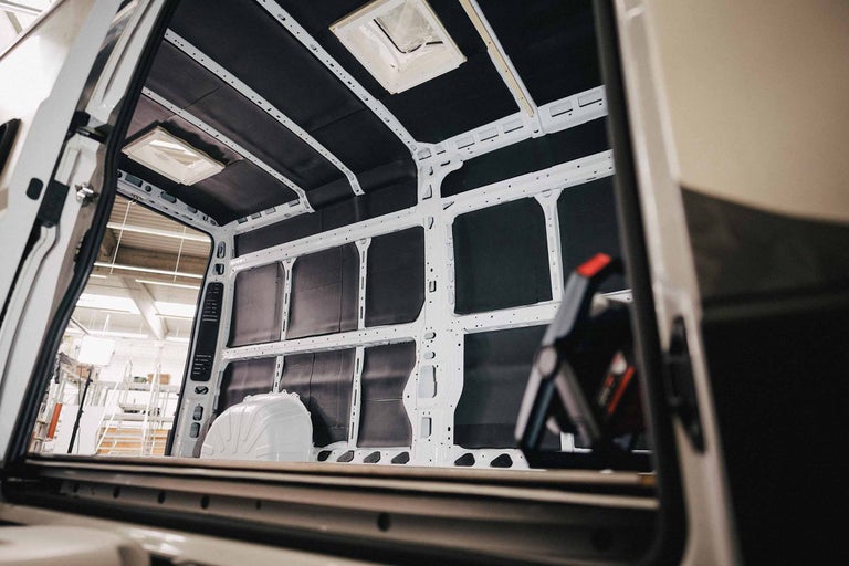 Interieur van een bestelwagen met isolatiemateriaal en dakramen