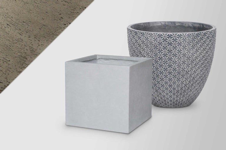 Twee plantenbakken van cement: een vierkante en een ronde pot met patroon