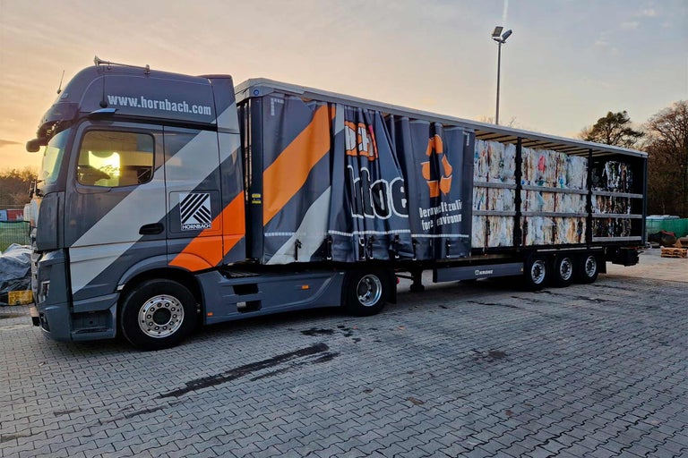 Een vrachtwagen met het Hornbach logo vervoert gerecyclede materialen.