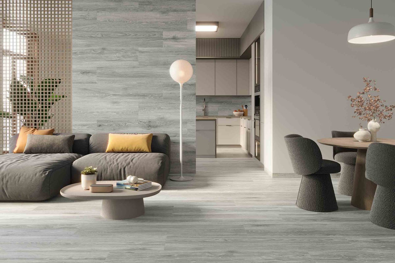 Lichte woonkamer met houtlook vloertegels, bank en eethoek