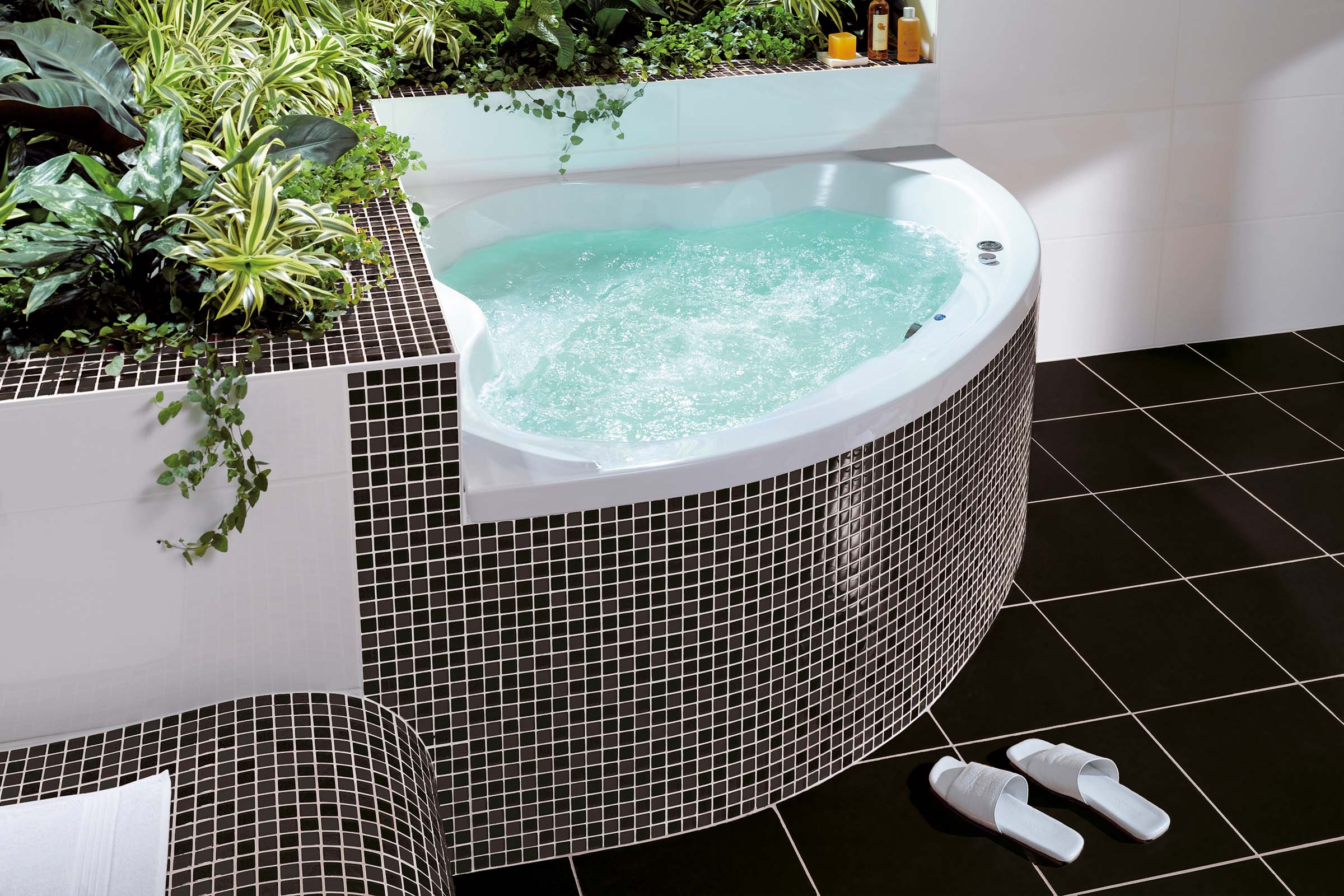 Badkamer met bubbelbad, mozaïektegels en planten