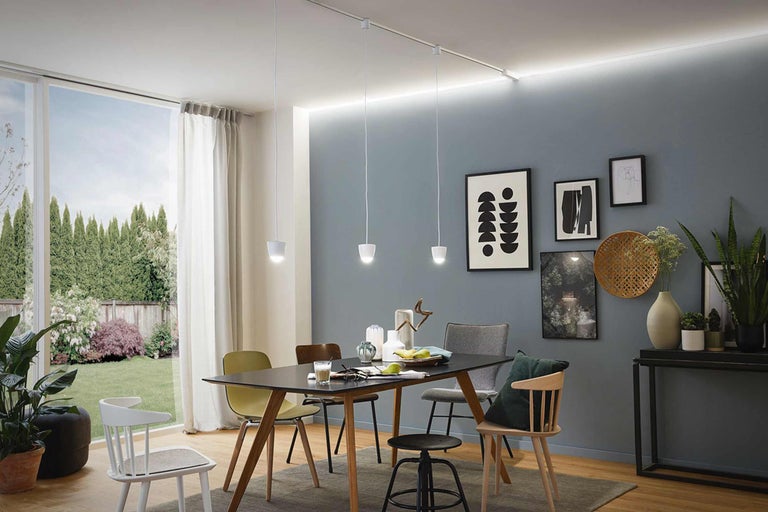 Eetkamer met eettafel, stoelen, hanglampen en decoraties.