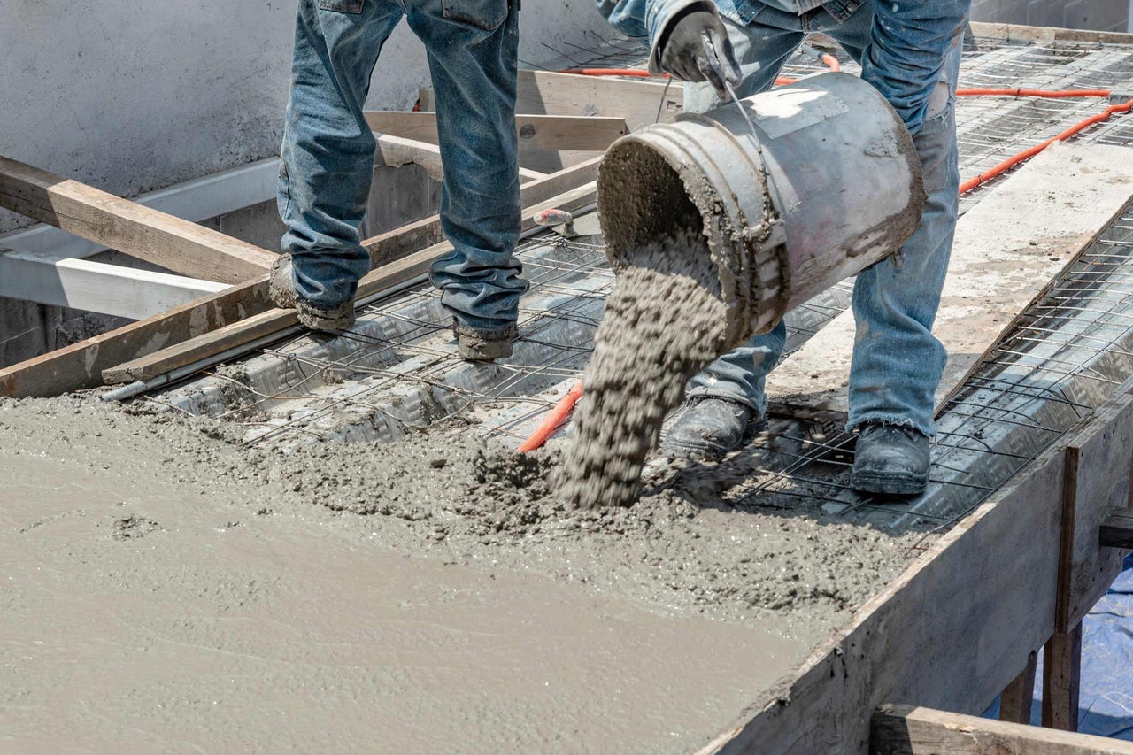 Bouwvakkers gieten beton op een bouwplaats