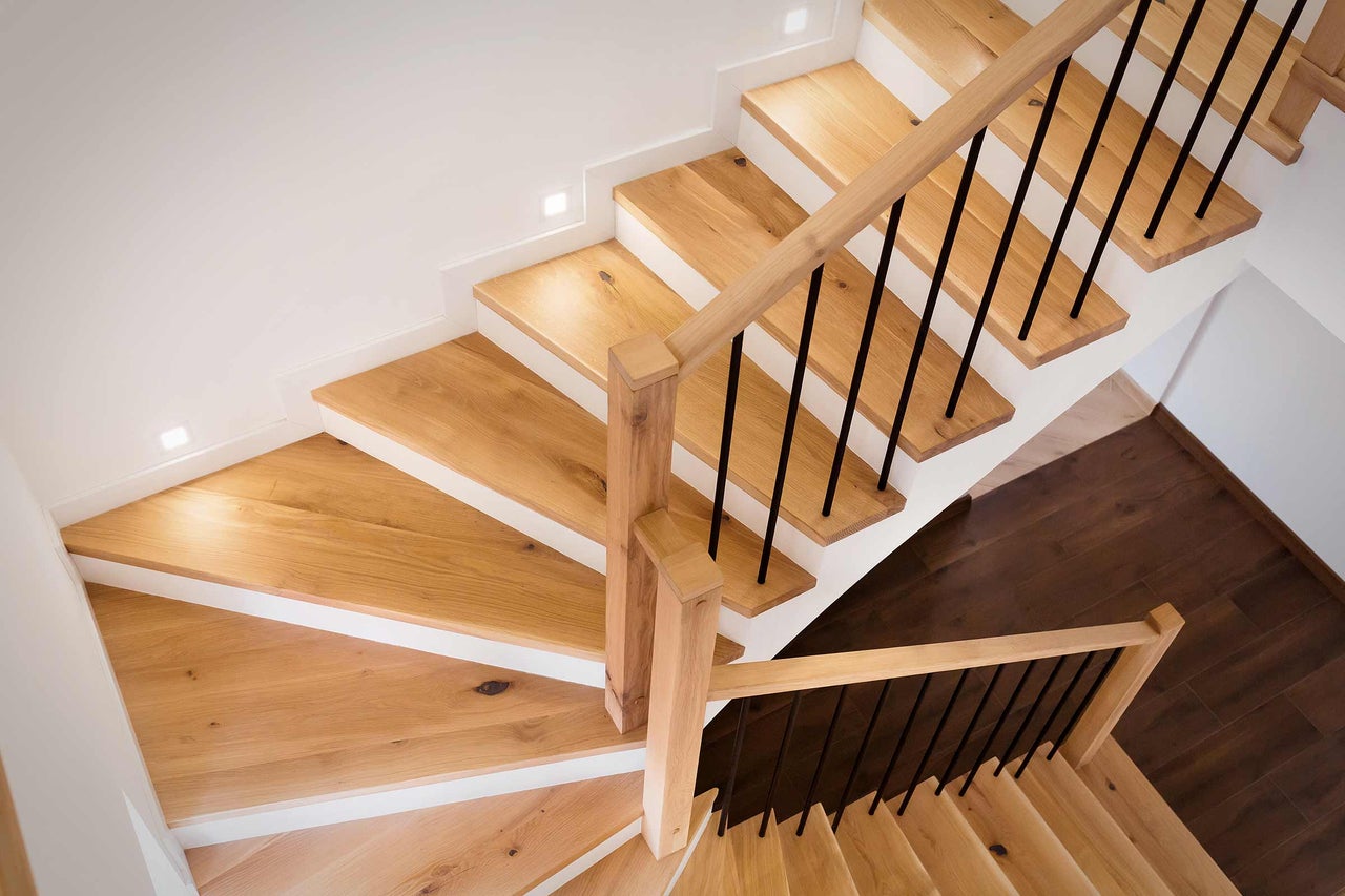 Houten trap met zwarte leuning in een licht interieur