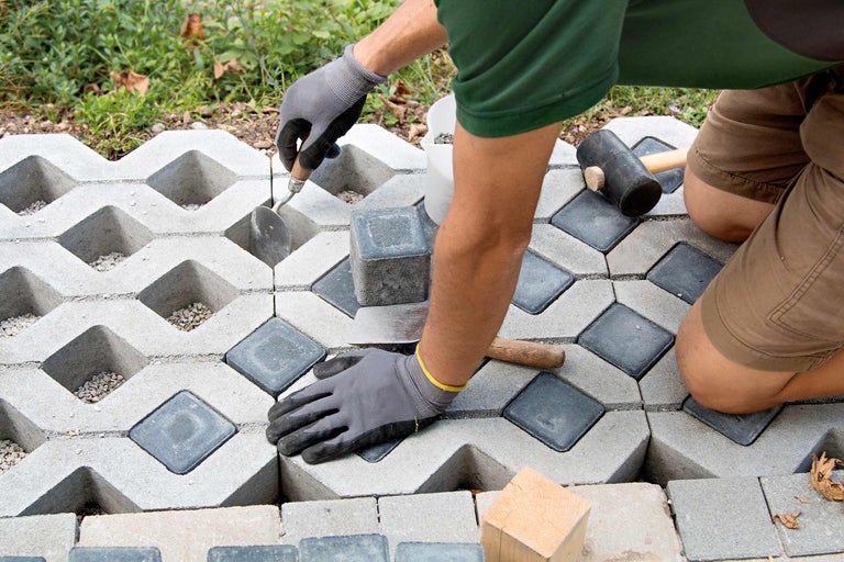 Man legt grasbetonstenen met straatstenen als vulling