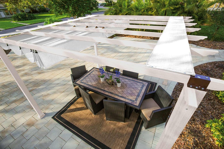 Pergola met zonwering, eettafel en stoelen op een terras
