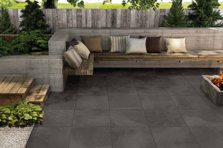 Terras met grijze tegels, bank en vuurplaats