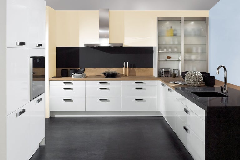 Moderne keuken met witte kasten, afzuigkap en zwart aanrechtblad