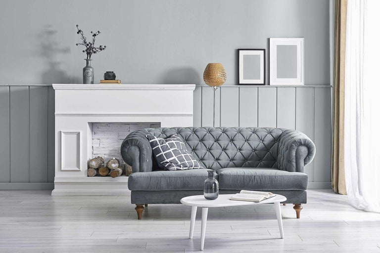 Woonkameropstelling met grijze bank, witte schouw en ronde tafel