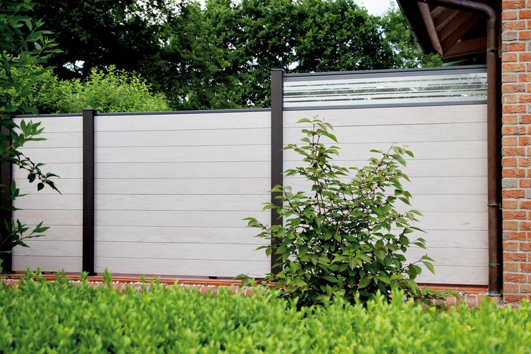 Buitenaanzicht van een tuinafscheiding met horizontale elementen en donkerbruine palen