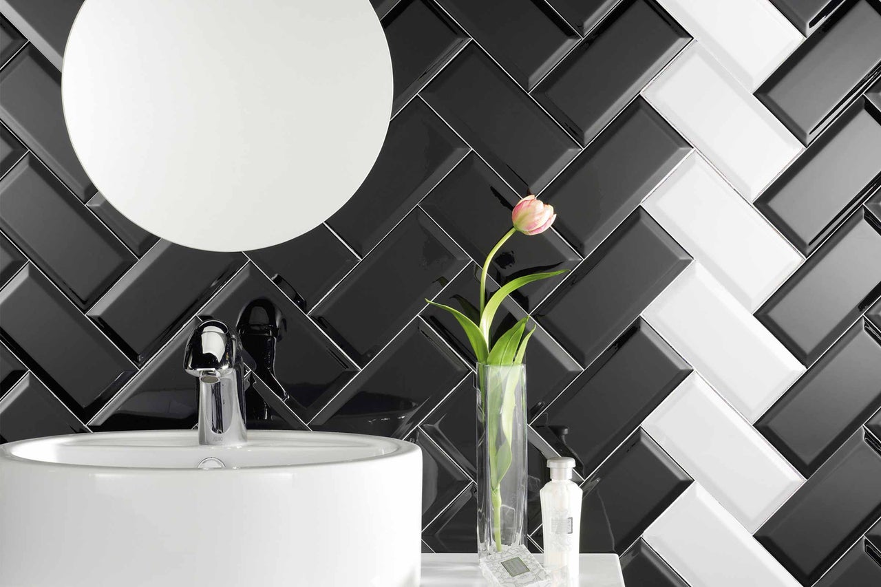 Badkamer met wastafel, kraan, spiegel en tegels in visgraatmotief