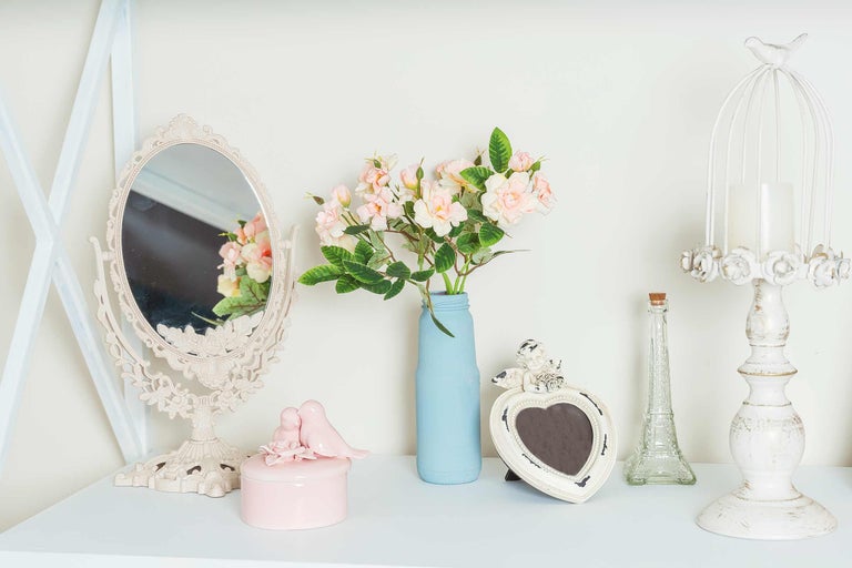 Decoratief arrangement met spiegel, bloemen in vaas, sieradendoos, fotolijst en kandelaar