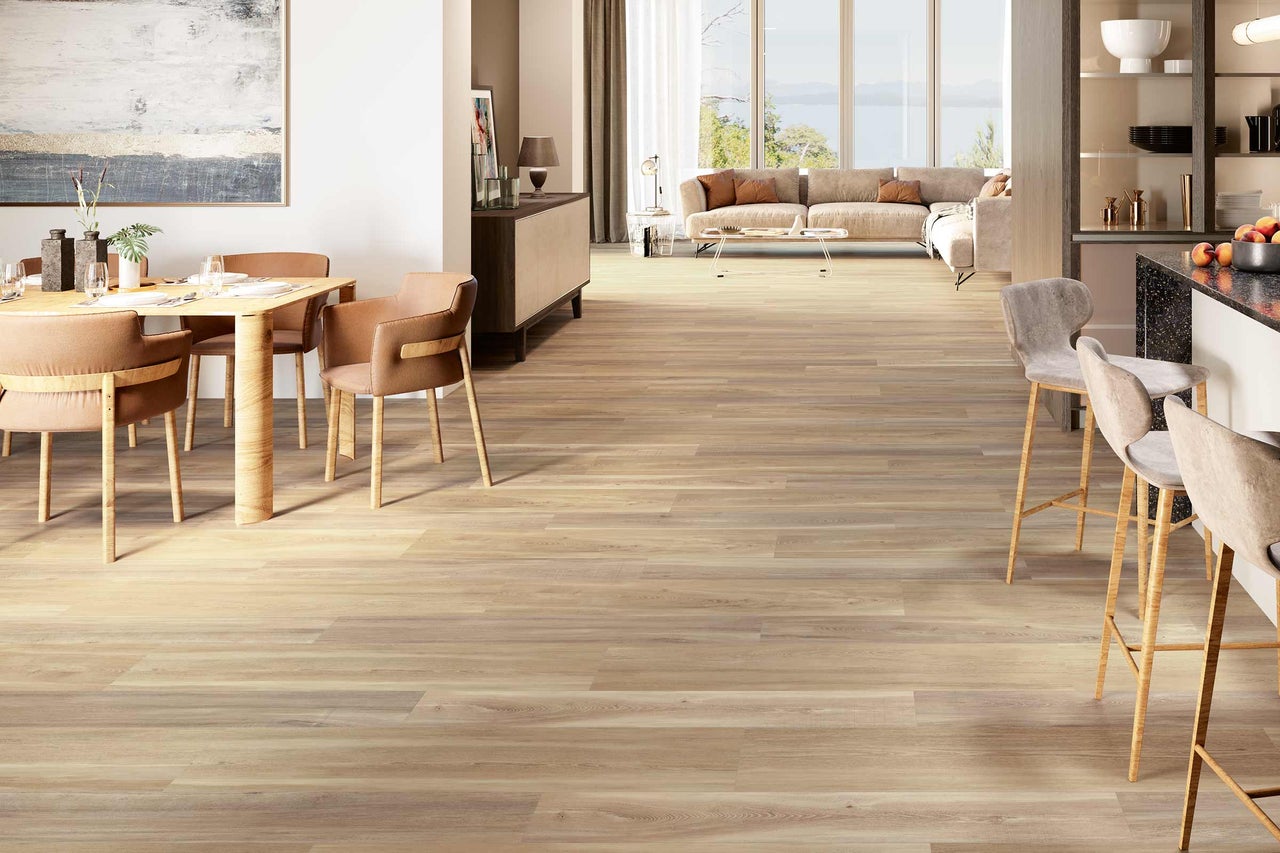 Lichte woonkamer met houten vloer, eettafel, stoelen en barkrukken.