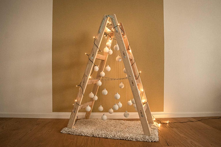 Decoratieve ladder met ballen en lichtsnoer als alternatief voor een kerstboom