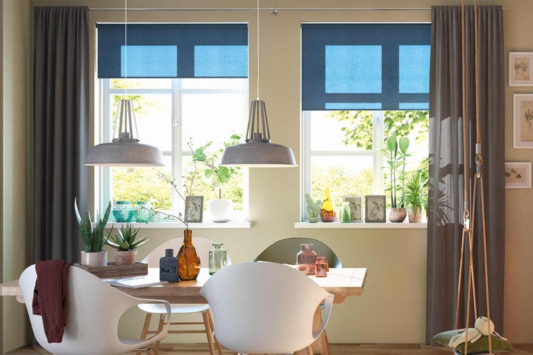 Eetkamer met eettafel, stoelen, raam met rolgordijnen en gordijnen