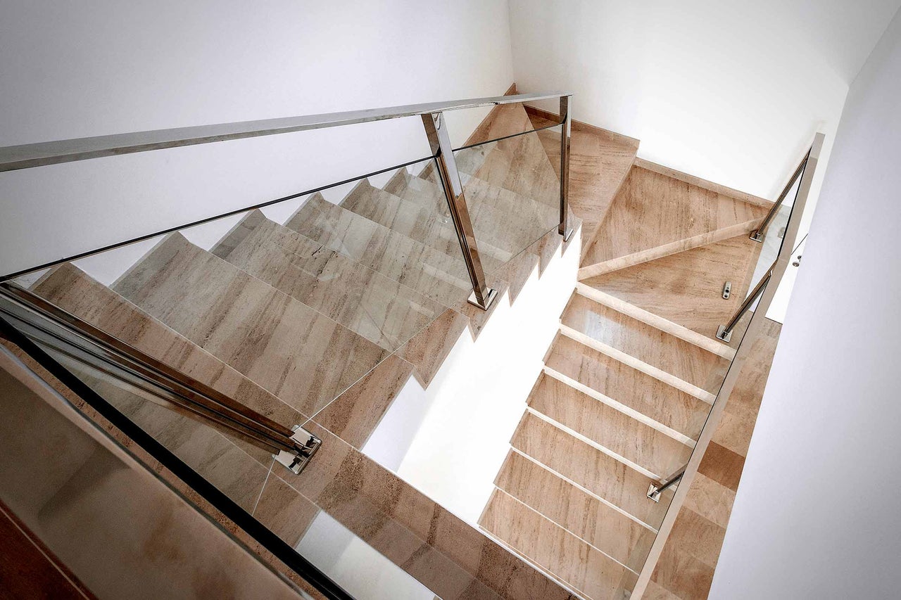 Trap met marmeren treden en glazen balustrade