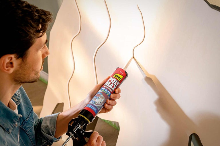 Man brengt UHU Poly Max montagelijm aan op een wandpaneel.