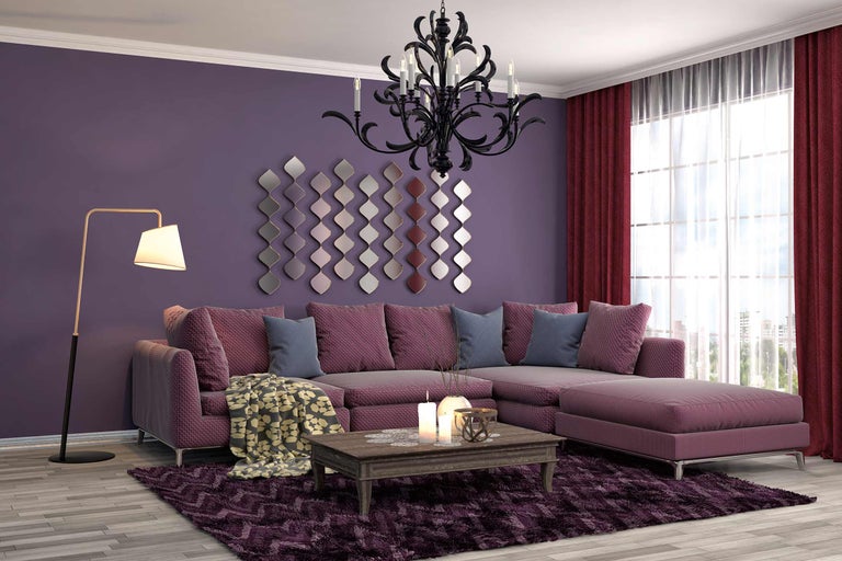 Woonkamer met hoekbank, vloerkleed, kroonluchter en decoratieve wanddecoratie