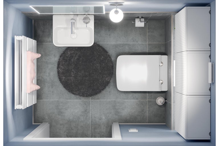 Bovenaanzicht van een badkamer met wastafel, toilet, radiator, kast en badmat