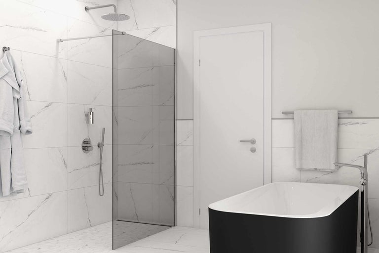 Badkamer met douche, bad, glazen scheidingswand, handdoeken en badjas