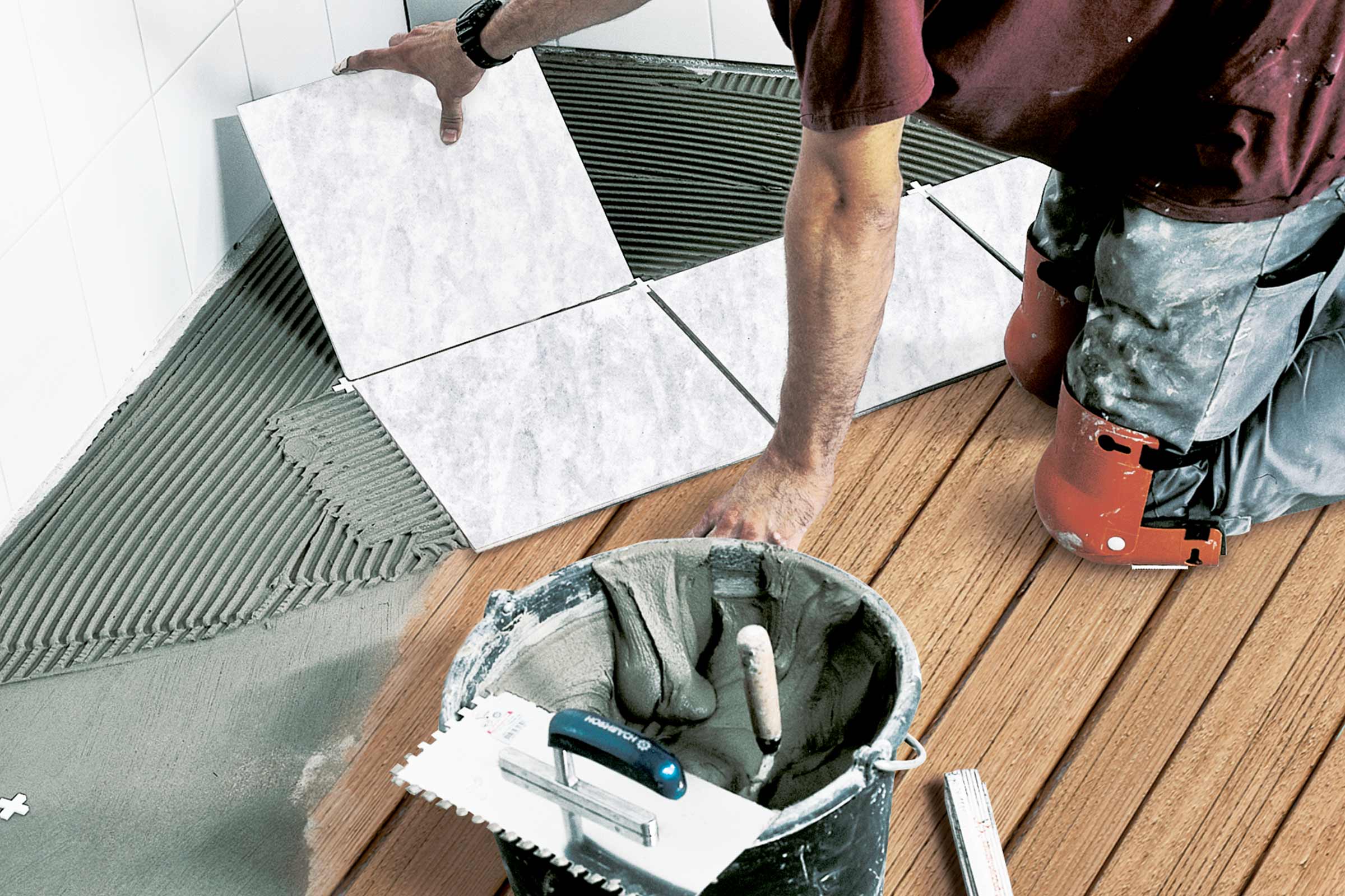 Tegelzetter aan het werk in de badkamer met gereedschap
