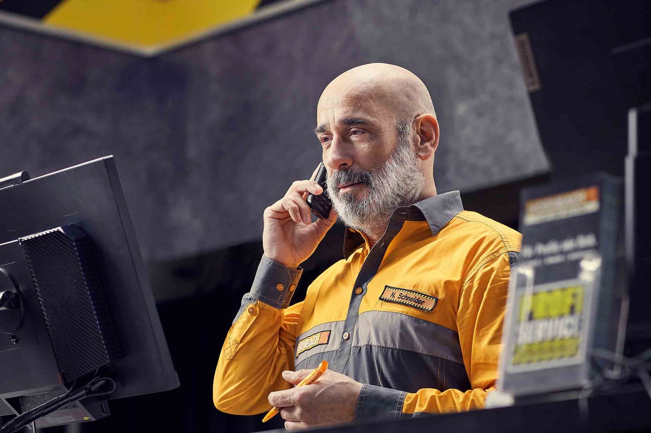 Een Hornbach medewerker telefoneert en houdt een pen in zijn hand.