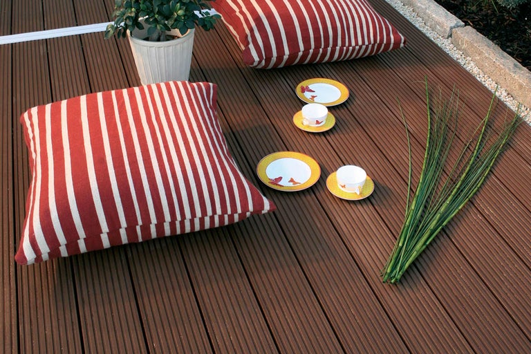 Terrasplanken met kussens, servies en plant