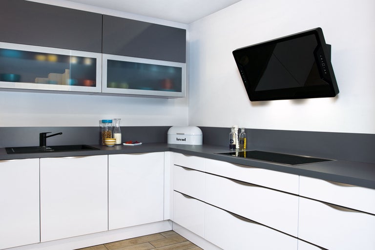 Lichte keuken met grijze en witte kasten en een afzuigkap