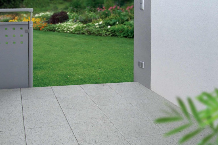 Buitenkant met terrastegels en tuinomheining